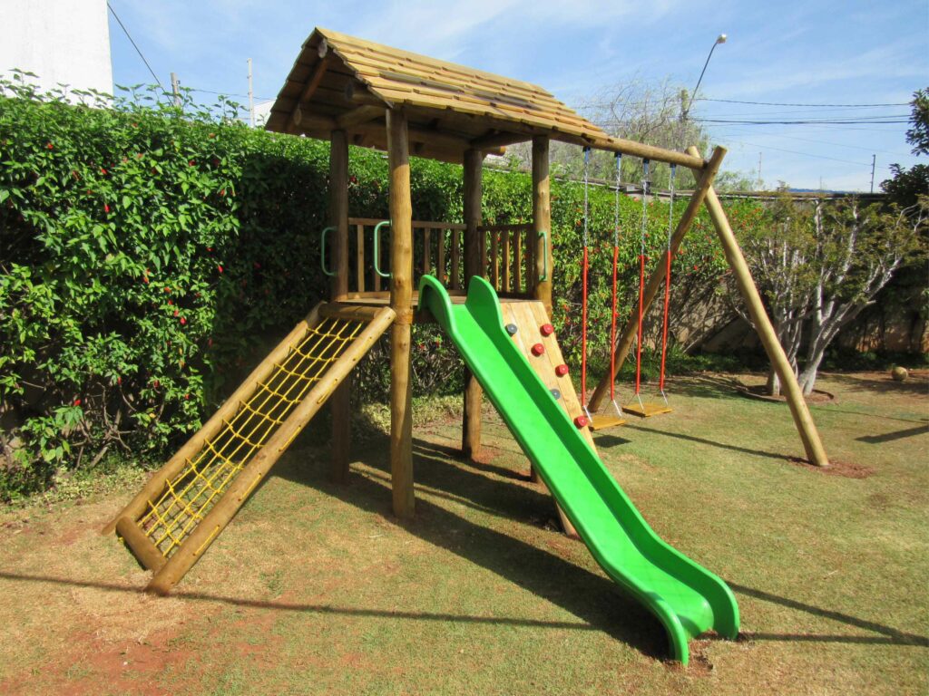 Playgrounds de madeira com tobogãs, túneis, balanços e muito mais, projetados para proporcionar uma experiência de brincadeira completa e segura para as crianças.