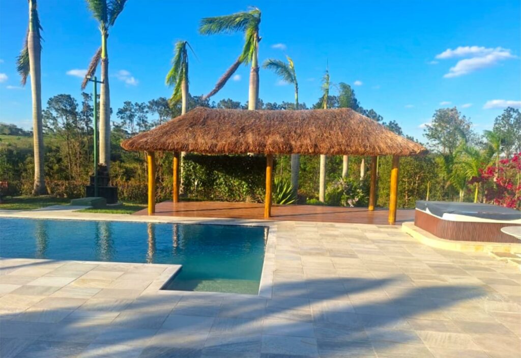 Quiosque de madeira e cobertura em sapê com piscina